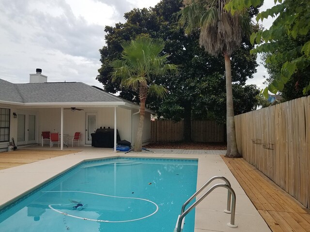 view of swimming pool featuring a deck and ceiling fan