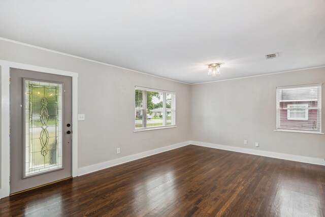 empty room featuring ornamental molding and dark hardwood / wood-style flooring