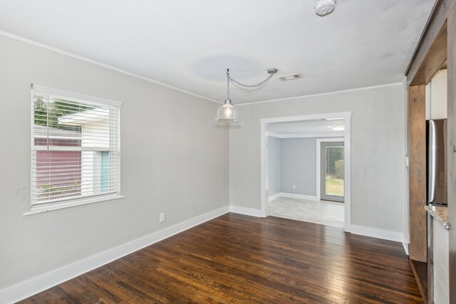 spare room featuring plenty of natural light, ornamental molding, and dark wood-type flooring