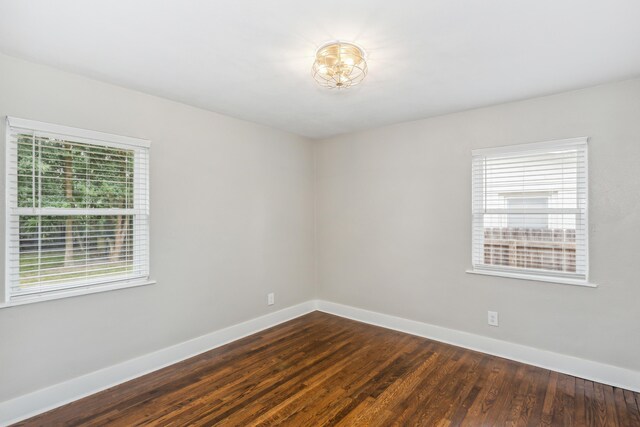 spare room with a wealth of natural light and hardwood / wood-style floors