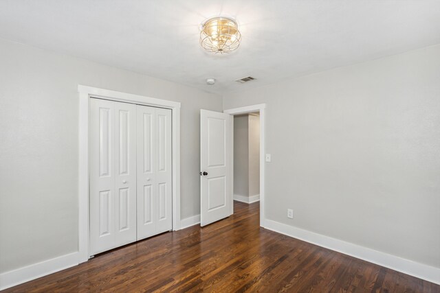 unfurnished bedroom featuring a closet and dark hardwood / wood-style floors