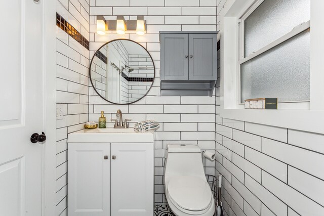 bathroom featuring tile walls, toilet, and vanity