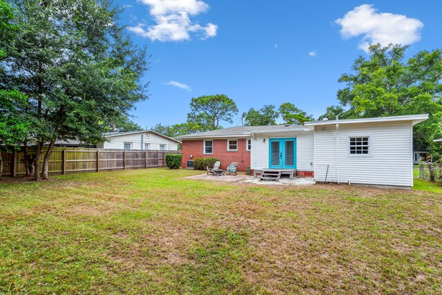 back of property featuring a patio area and a lawn