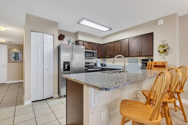 520 Santa Rosa Blvd Unit 301, Fort Walton Beach, FL 32548 - kitchen with a peninsula, stainless steel appliances, dark brown cabinets, a sink, and a breakfast bar area