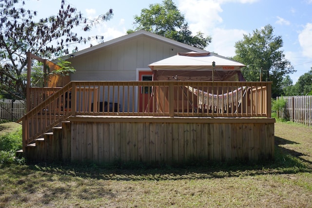 back of house with a wooden deck and a lawn