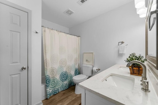 full bathroom with toilet, hardwood / wood-style flooring, shower / tub combo, and vanity