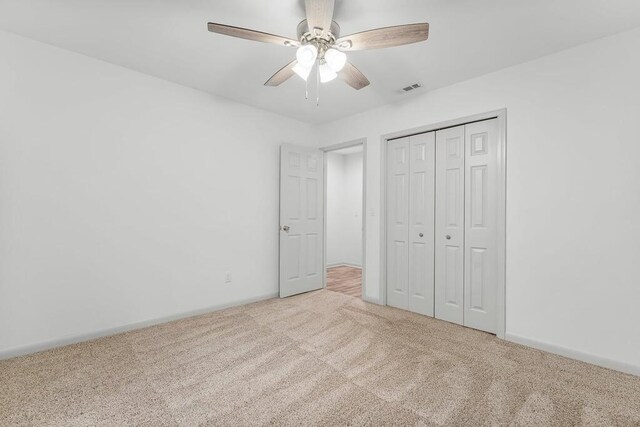 unfurnished bedroom with a closet, ceiling fan, and carpet flooring