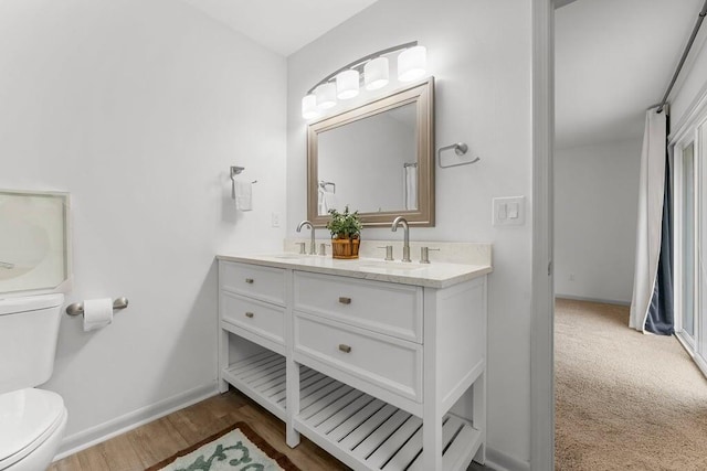 bathroom with vanity, toilet, and wood-type flooring