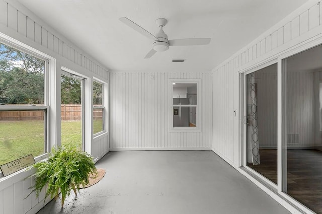 unfurnished sunroom with ceiling fan