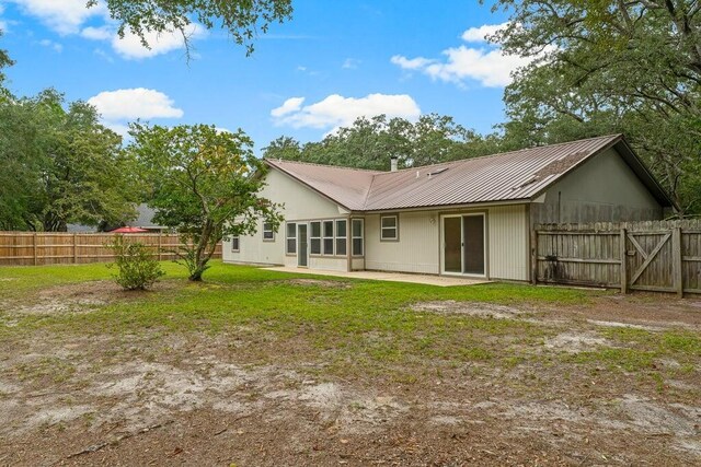 rear view of house with a lawn and a patio