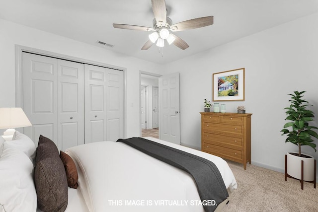 bedroom featuring ceiling fan, a closet, and light carpet