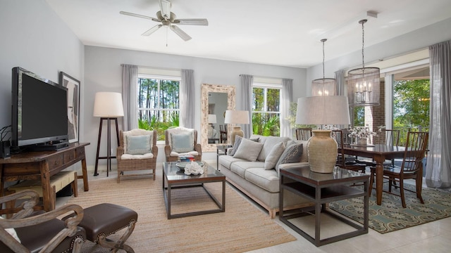 tiled living room featuring ceiling fan with notable chandelier