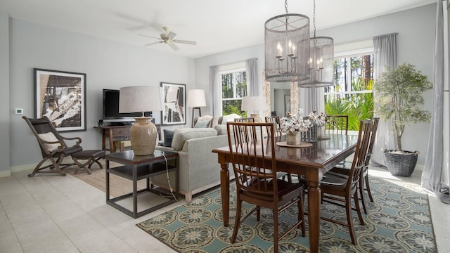 tiled dining room featuring ceiling fan with notable chandelier