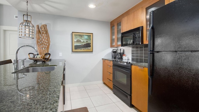 kitchen featuring light tile patterned flooring, pendant lighting, sink, dark stone counters, and black appliances