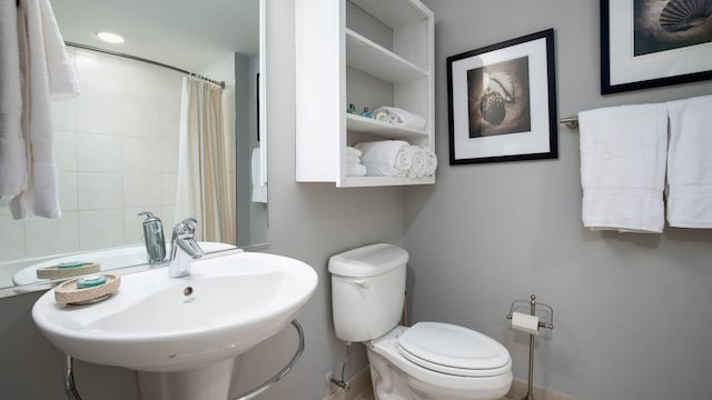 bathroom featuring a shower with curtain, sink, and toilet