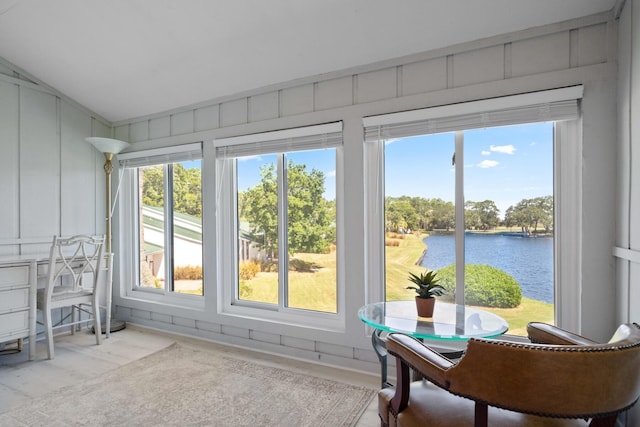 sunroom / solarium featuring a water view, a healthy amount of sunlight, and vaulted ceiling