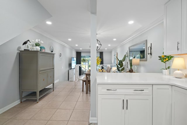 kitchen featuring white cabinets, ornamental molding, and light tile patterned floors