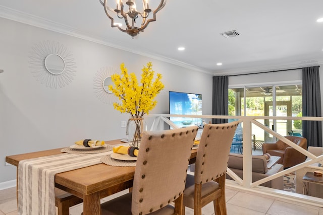 dining room with an inviting chandelier, ornamental molding, and light tile patterned flooring