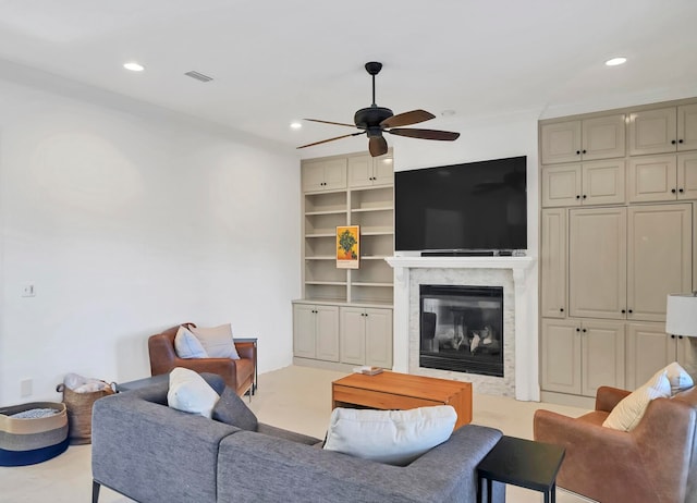 living room with ceiling fan, ornamental molding, and a premium fireplace