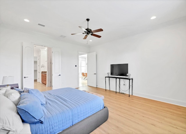 bedroom featuring hardwood / wood-style floors, ceiling fan, and ensuite bath