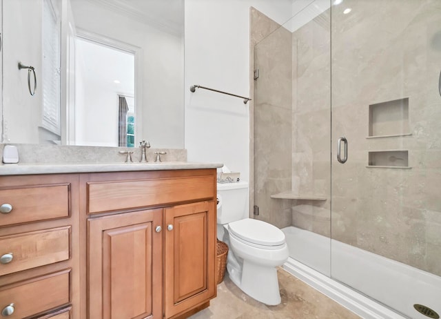 bathroom with vanity, toilet, ornamental molding, and a shower with shower door