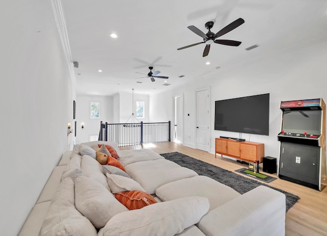 living room featuring light hardwood / wood-style flooring, ceiling fan, and ornamental molding