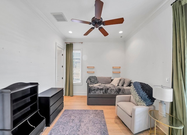 living room featuring light wood-type flooring, ceiling fan, and ornamental molding