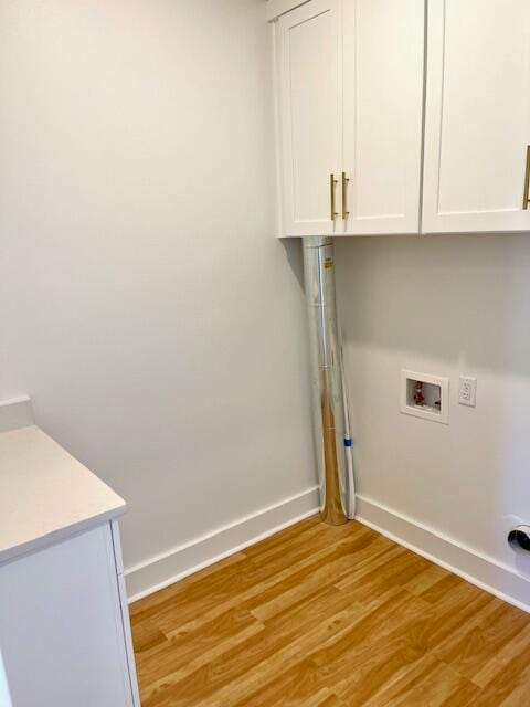 laundry area with hookup for a washing machine, light hardwood / wood-style flooring, and cabinets