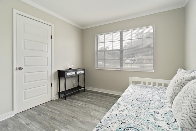 bedroom featuring crown molding and light hardwood / wood-style floors