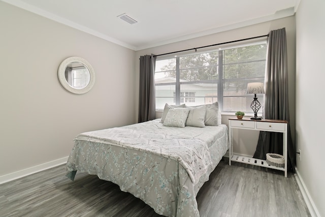 bedroom featuring crown molding and dark hardwood / wood-style floors