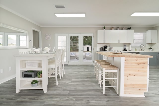 kitchen featuring light hardwood / wood-style flooring, a kitchen bar, and ornamental molding