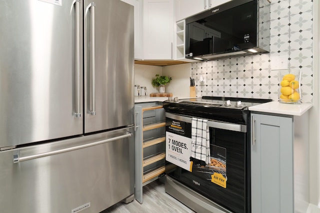 kitchen featuring stainless steel fridge, light hardwood / wood-style flooring, backsplash, electric stove, and white cabinets