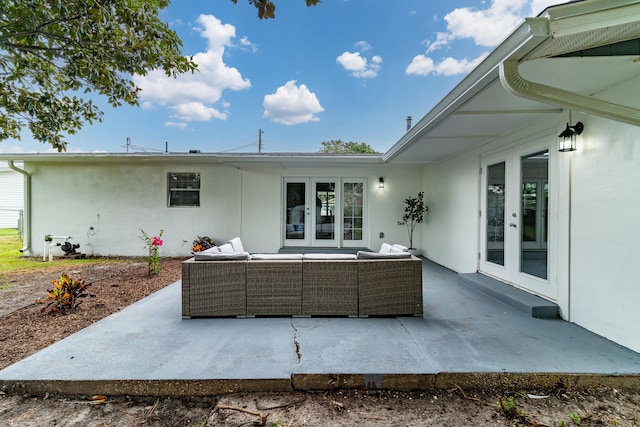 rear view of house with a patio area, an outdoor living space, and french doors