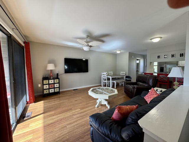 living room with wood-type flooring and ceiling fan