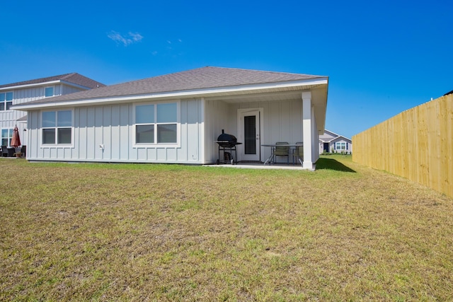 rear view of property featuring a lawn and a patio area