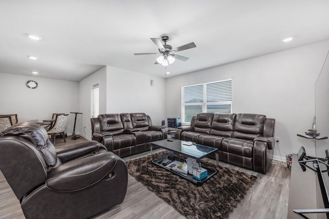 living room with light wood-type flooring and ceiling fan