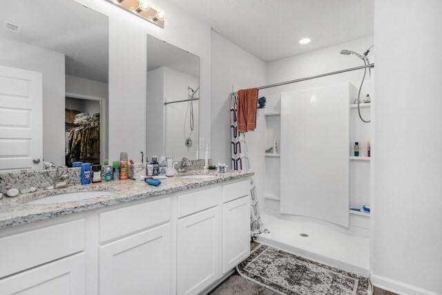 bathroom with a shower and vanity