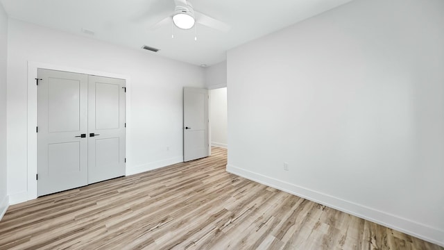 unfurnished bedroom featuring a closet, light hardwood / wood-style floors, and ceiling fan