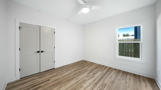 unfurnished bedroom featuring ceiling fan, a closet, and light hardwood / wood-style flooring