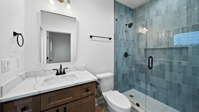 bathroom with vanity, an enclosed shower, and toilet