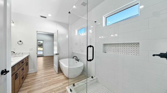 bathroom featuring wood-type flooring, vanity, and independent shower and bath