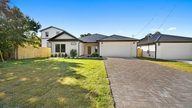 view of front of house featuring a garage and a front lawn