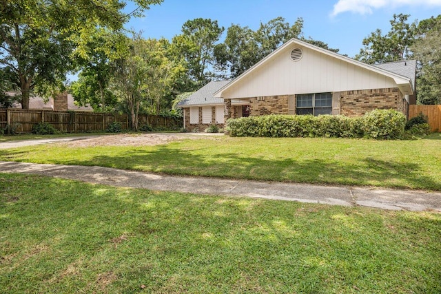 2205 Calle De Marbella, Navarre, FL 32566 - exterior space featuring brick siding, a front lawn, and fence