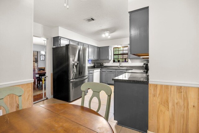 2205 Calle De Marbella, Navarre, FL 32566 - kitchen with visible vents, dishwasher, light tile patterned floors, gray cabinets, and stainless steel refrigerator with ice dispenser