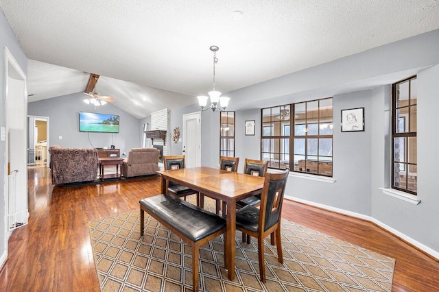 2205 Calle De Marbella, Navarre, FL 32566 - dining space with wood finished floors, baseboards, lofted ceiling, a textured ceiling, and a brick fireplace