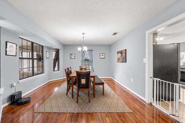 2205 Calle De Marbella, Navarre, FL 32566 - dining area with visible vents, wood finished floors, a textured ceiling, and a chandelier