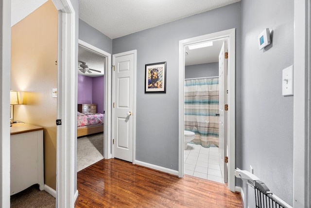 2205 Calle De Marbella, Navarre, FL 32566 - corridor with baseboards, a textured ceiling, and wood finished floors