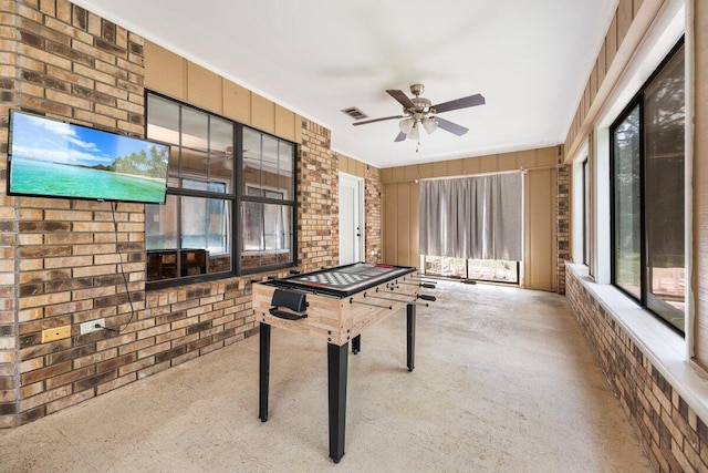 2205 Calle De Marbella, Navarre, FL 32566 - rec room featuring brick wall, concrete flooring, and a ceiling fan