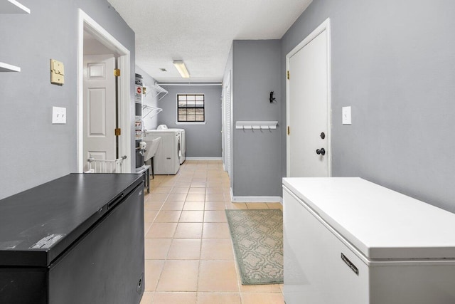 2205 Calle De Marbella, Navarre, FL 32566 - washroom featuring washer and clothes dryer, a textured ceiling, light tile patterned floors, baseboards, and laundry area