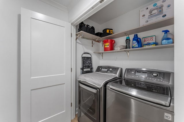 clothes washing area featuring ornamental molding and washer and clothes dryer